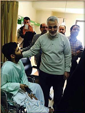 عیادت سردار سلیمانی از یک جانباز مدافع حرم/عکس