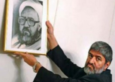عل مطهری در حال نصب عکس مرحوم پدرش