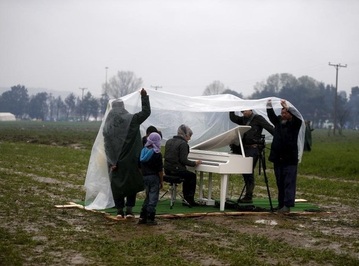 یک پناهنده سوری، با وجود بی‌خانمانی، در زیر بارش باران پیانو می‌نوازد 